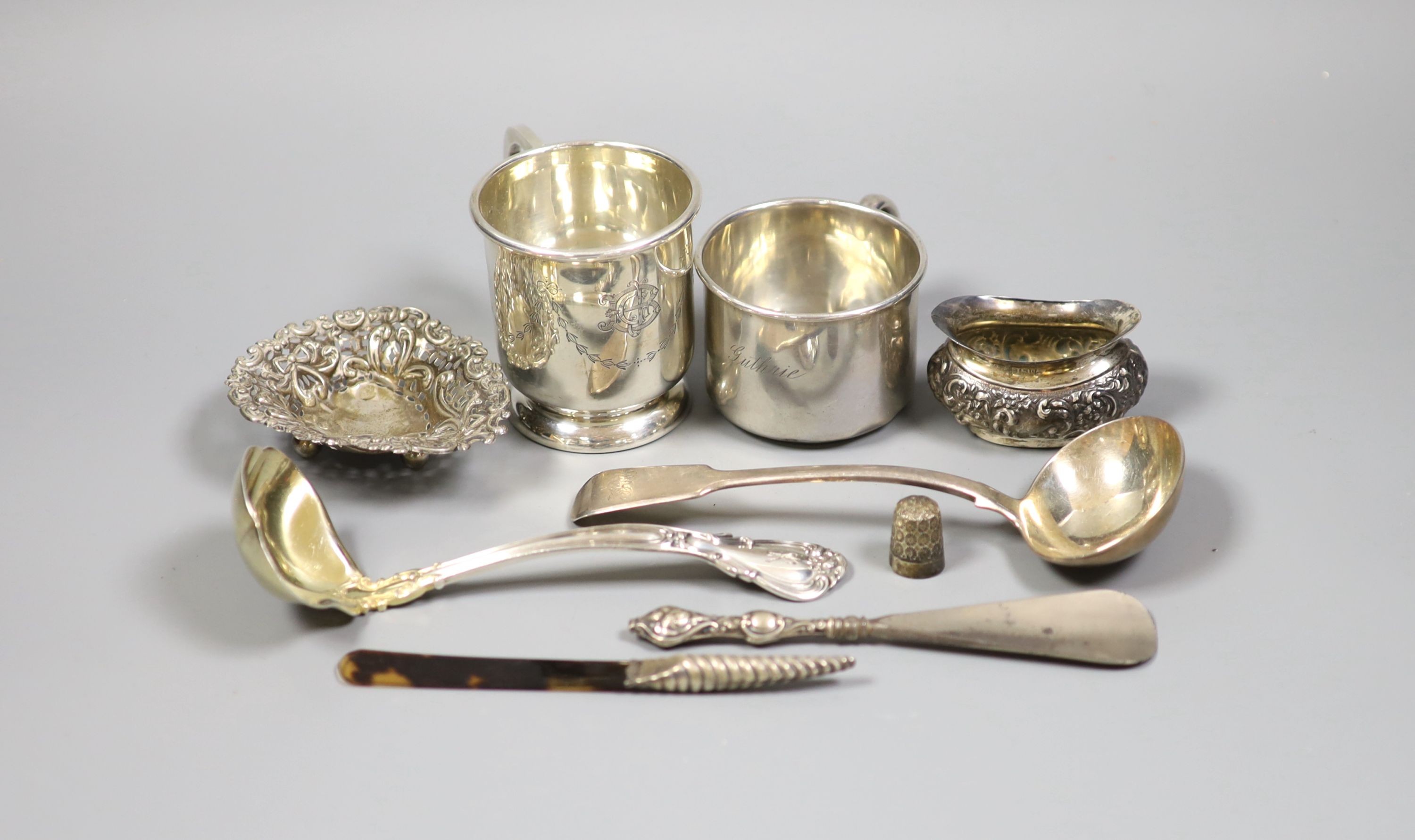 Mixed silver and sterling items including two mugs, two sauce ladles, salt thimble, nut dish and two silver handled implements